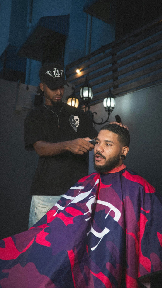 Barber cutting client's hair with clippers.