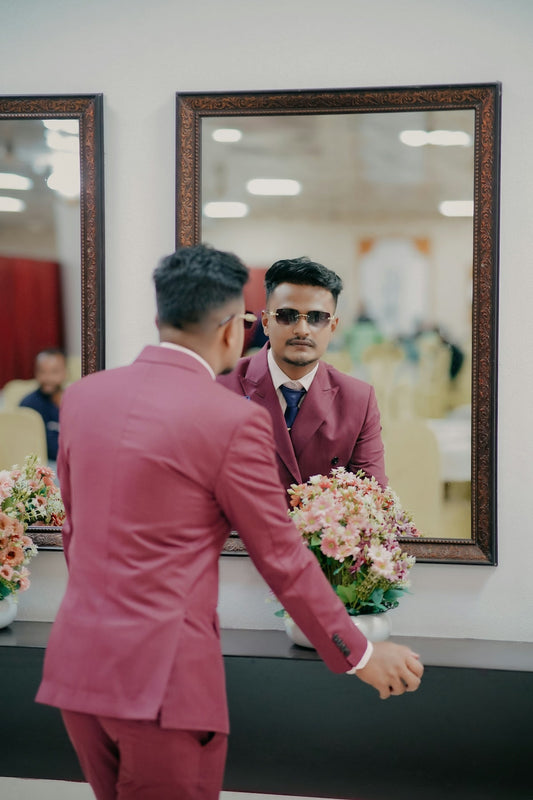Man in maroon suit and sunglasses reflected in mirror